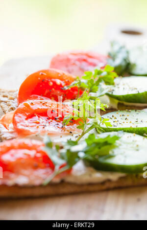 Gesunde Ernährung, helle Frühstück Sandwiches. Finnische Roggen Knäckebrot, Weichkäse, Gurken, Tomaten, Petersilie und Pfeffer Stockfoto