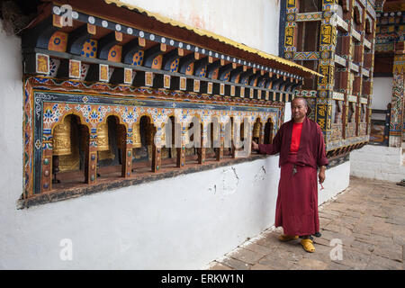 Ein Mönch dreht sich die Walze-Bücher aus dem Kloster von Punakha Dzong, die verwendet werden, um zu beten, Paro, Bhutan, Asien Stockfoto