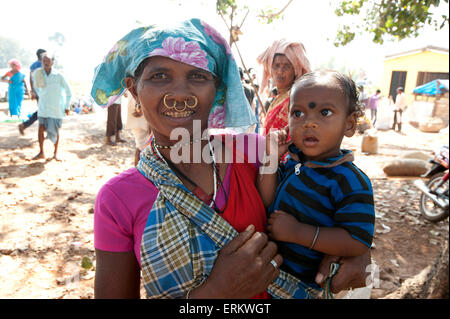 Mali Tribeswoman mit Nase und Ohr Goldringe mit ihrem Sohn in Mali Stammes-Wochenmarkt, Guneipada, Orissa (Odisha), Indien Stockfoto