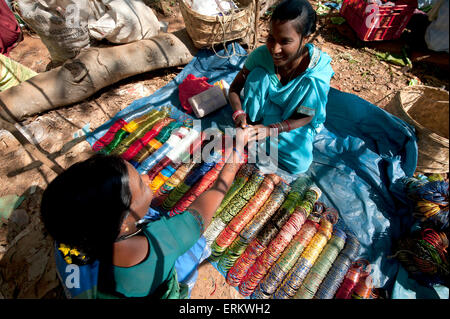 Junge Frau in Türkis Sari Verkauf Armreifen in Mali wöchentliche tribal, Guneipada, Koraput Marktviertel, Orissa (Odisha), Indien Stockfoto