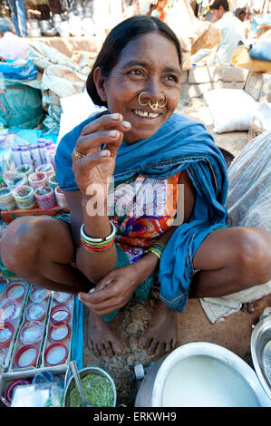 Lächelnd Mali Tribeswoman mit gold Noserings Verkauf von Joghurt in Mali Stammes-Wochenmarkt, Guneipada, Orissa (Odisha), Indien Stockfoto