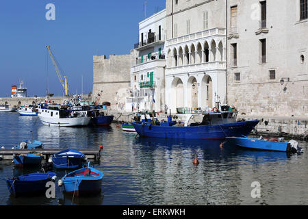 Blaue Holzboote und Fischereifahrzeuge im ummauerten Hafen von Monopoli in Apulien, Italien, Europa Stockfoto