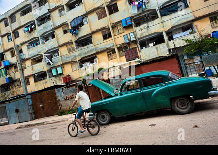 Ein junger kubanischer Mann fährt Fahrrad vor der riesigen Wohnblocks in Alamar, eine Sozialwohnung Peripherie von Havanna, Kuba. Stockfoto