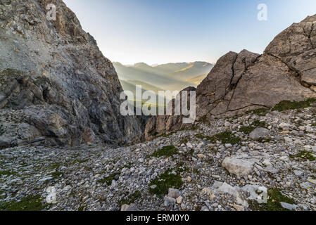 Letzte wärmende Sonnenstrahlen auf Susa-Tal mit leuchtenden Berggipfel und üppigen grünen Wäldern. Weitwinkel-Ansicht von oben. Stockfoto