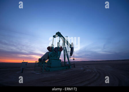 Ein Bohrschwengels in einer Öl-Bohr-Website bei Sonnenuntergang. Stockfoto