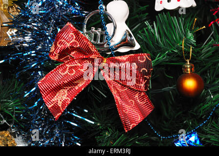 Rote Schleife Knoten hängen Tannenbaum mit anderen Dekoration Stockfoto