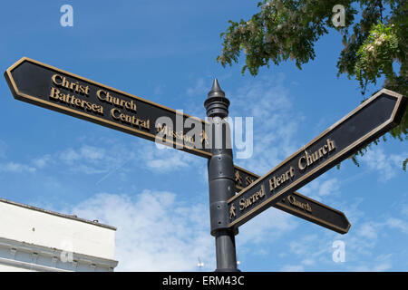 Wegweiser in Battersea High Street, London, England, Wegbeschreibungen zu Christus Kirche zentrale Mission und Kirche des Heiligen Herzen Jesu Stockfoto