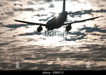 Düsen im Endanflug Silhouette mit Streuwolke und Sonne hinter Heck Flugzeugs Hintergrund Stockfoto