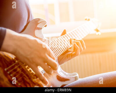 Männliche Hand auf der akustischen Gitarre zu spielen. Close-up. Stockfoto