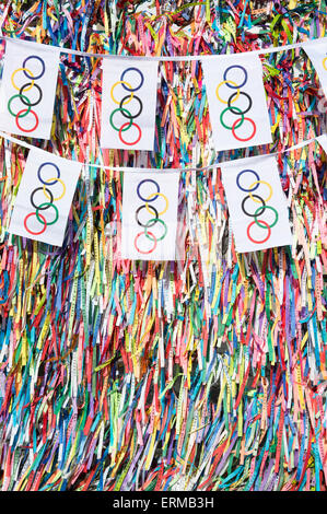 SALVADOR, Brasilien - 11. März 2015: Olympische Flagge Bunting hängt vor dem Hintergrund des guten Glücks brasilianische wünschen Bänder. Stockfoto