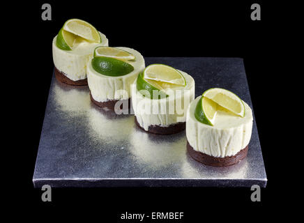Vier kleine Kuchen verziert mit Limettenscheiben Stockfoto