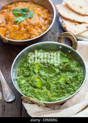 Indische Küche: Palak Paneer und Paneer Tikka Masala in traditionellen Kupfer Schalen zusammen mit tandoori Roti Brot serviert. Stockfoto