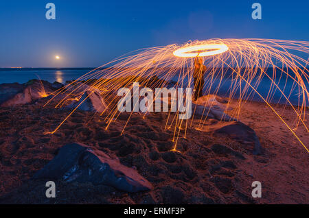 Silhouette des Menschen Spinnen beleuchtet Stahlwolle bei Nacht, Hayling Island, Strand mit blauer Flagge, Hampshire, England, South UK Stockfoto