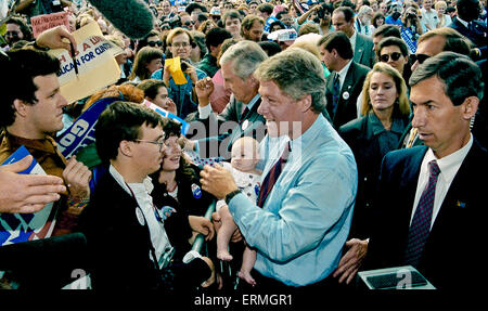 Dallas, Texas, USA 28. Oktober 1992 Arkansas Gouverneur William Jefferson Clinton hält ein Kind während der Arbeit der Seil-Linie bei einer Kundgebung der Kampagne in Dallas. Texas Senator Lloyd Bentsen steht neben dem Gouverneur Clinton und Texas Gouverneur Ann. Richards im Hintergrund mit dem weißen Haar und trug eine grüne Jacke. Blonde Frau über Clintons linke Schulter ist Secret Service-Agent, die oft mit den Kandidaten gesehen. Bildnachweis: Mark Reinstein Stockfoto