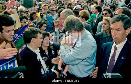 Dallas, Texas, USA 28. Oktober 1992 Arkansas Gouverneur William Jefferson Clinton hält ein Kind während der Arbeit der Seil-Linie bei einer Kundgebung der Kampagne in Dallas. Texas Senator Lloyd Bentsen steht neben dem Gouverneur Clinton und Texas Gouverneur Ann. Richards im Hintergrund mit dem weißen Haar und trug eine grüne Jacke. Blonde Frau über Clintons linke Schulter ist Secret Service-Agent, die oft mit den Kandidaten gesehen. Bildnachweis: Mark Reinstein Stockfoto