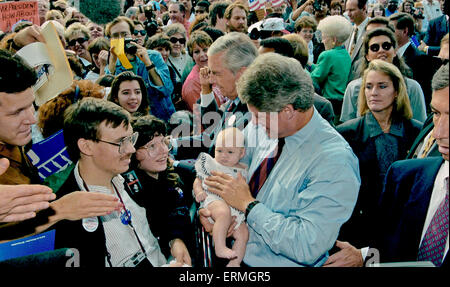 Dallas, Texas, USA 28. Oktober 1992 Arkansas Gouverneur William Jefferson Clinton hält ein Kind während der Arbeit der Seil-Linie bei einer Kundgebung der Kampagne in Dallas. Texas Senator Lloyd Bentsen steht neben dem Gouverneur Clinton und Texas Gouverneur Ann. Richards im Hintergrund mit dem weißen Haar und trug eine grüne Jacke. Blonde Frau über Clintons linke Schulter ist Secret Service-Agent, die oft mit den Kandidaten gesehen. Bildnachweis: Mark Reintein Stockfoto