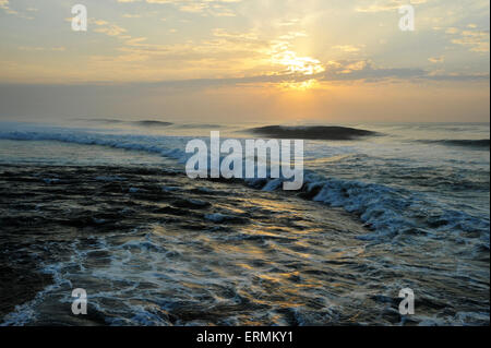 Wunderschöner dramatischer Sonnenaufgang über dem Meer, atemberaubende Meereslandschaft, minimale Landschaft, Durban, Südafrika, Brechende Welle, Küstenwetter, atmosphärischer Morgen Stockfoto