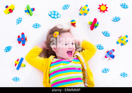 Kind spielt mit hölzernen Flugzeugen. Vorschulkind Kind rund um die Welt fliegen. Kinder reisen und spielen. Stockfoto