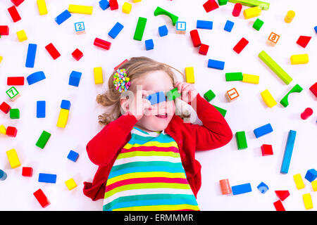 Kind spielt mit bunten Holzspielzeug. Kleines Mädchen mit Bildungs-Spielzeug-Blöcken. Kinder spielen in Kita oder Vorschule Stockfoto