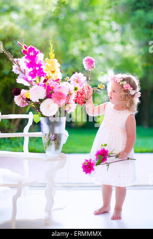 Kleines Mädchen zu Hause Blumen in einer Vase arrangieren. Kind spielt im Innenbereich. Kinder-Geburtstags-Party. Kinder Blume als Geschenk zu geben. Stockfoto