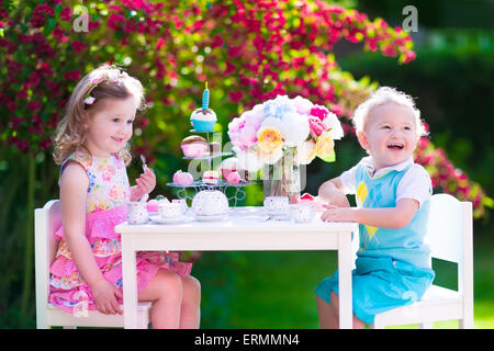 Tea Garden Party für Kinder. Kind Geburtstag feiern. Kleine Jungen und Mädchen spielen im freien heißen Schokolade trinken und Kuchen essen. Stockfoto