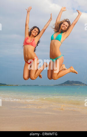 Teenager Schwestern am Strand in die Luft springen; Kailua, Insel Hawaii, Hawaii, Vereinigte Staaten von Amerika Stockfoto