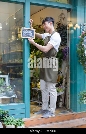 Blumengeschäft hält ein Schild "geöffnet" Stockfoto