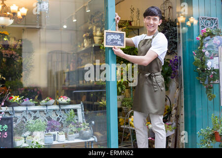 Blumengeschäft hält ein Schild "geöffnet" Stockfoto