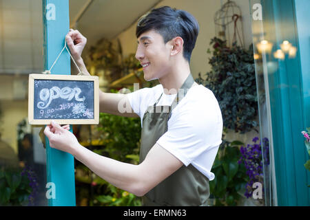 Blumengeschäft hält ein Schild "geöffnet" Stockfoto