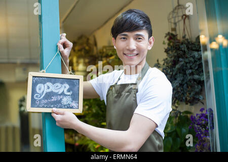 Blumengeschäft hält ein Schild "geöffnet" Stockfoto