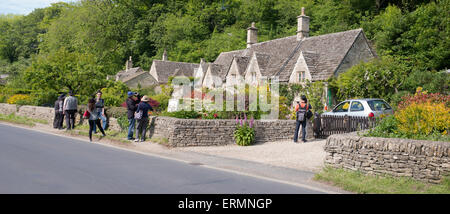 Asiatische Touristen fotografieren des siebzehnten Jahrhunderts Steinhütten in Bibury, Cotswolds, Gloucestershire, England Stockfoto