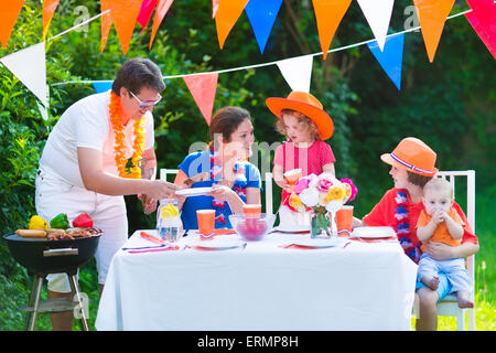 Große niederländische Familie mit Kindern feiern Nationalfeiertag oder Sport-Sieg, die Spaß am Grill-Party im Garten dekoriert mit Flagge Stockfoto