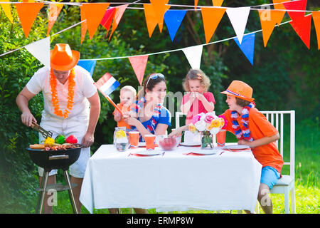 Große niederländische Familie mit Kindern feiern Nationalfeiertag oder Sport-Sieg, die Spaß am Grill-Party im Garten dekoriert mit Flagge Stockfoto