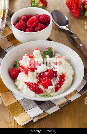 Frischer Quark mit frischen Beeren auf einem Holztisch. Ansicht von oben. Stockfoto