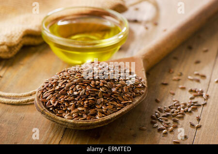 Brauner Leinsamen auf einem Löffel und Leinsamen-Öl. Stockfoto