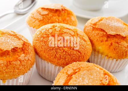 Nahaufnahme von einem Haufen von Magdalenas, die typisch spanische schlicht Muffins, in einem weißen Teller auf einem gedeckten Tisch bei einer Tasse Kaffee oder Tee Stockfoto