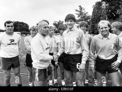 Birmingham City Football Manager Ron Saunders grüßt Stürmer Mick Harford und Teamkollegen Blues, wie sie für die Saisonvorbereitung berichten. 21. Juli 1982. Stockfoto