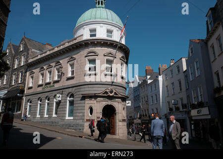 Lloyds Bank, High Street St Peter Port Guernsey moderne Ansicht, dass ein altes Bild aus der Besetzung von deutschen Soldaten in der Straße marschieren übereinstimmt Stockfoto