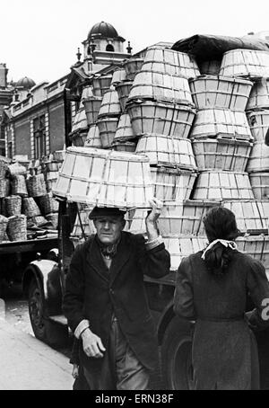 Covent Garden Market, älterer Mann trug Körbe auf dem Kopf durch die Marktstraßen. Ca. 1955. Stockfoto