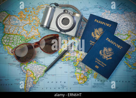 Reisepässe für Reisen, Kamera und Gläser auf einer Karte der Welt Stockfoto