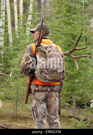 erfolgreiche Gewehr Jäger Wandern in Wäldern Stockfoto