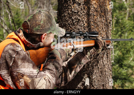 Erwachsenen Jäger mit dem Ziel Hirsch Gewehr im Wald Stockfoto