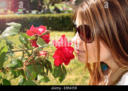 Mädchen riechen rote Rosen Stockfoto