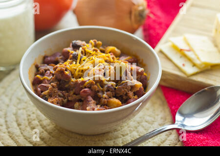 Scharf und würzig Chili Con Carne mit einem Glas Milch und Pfeffer Jack Käse Stockfoto