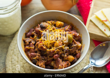 Scharf und würzig Chili Con Carne mit einem Glas Milch und Pfeffer Jack Käse Stockfoto