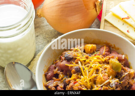 Scharf und würzig Chili Con Carne mit einem Glas Milch und Pfeffer Jack Käse Stockfoto