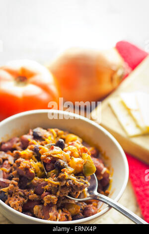 Scharf und würzig Chili Con Carne mit einem Glas Milch und Pfeffer Jack Käse Stockfoto