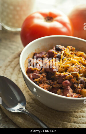 Scharf und würzig Chili Con Carne mit einem Glas Milch und Pfeffer Jack Käse Stockfoto