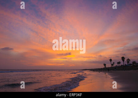 Rosa, orange, Pfirsiche und blaue Farben strömen durch den Himmel und vor der Küste des Pazifik Strandes zu reflektieren. Stockfoto