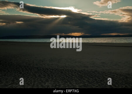 Sonnenlicht durch Regen Sturm über Nairn Strand in der Abenddämmerung Stockfoto